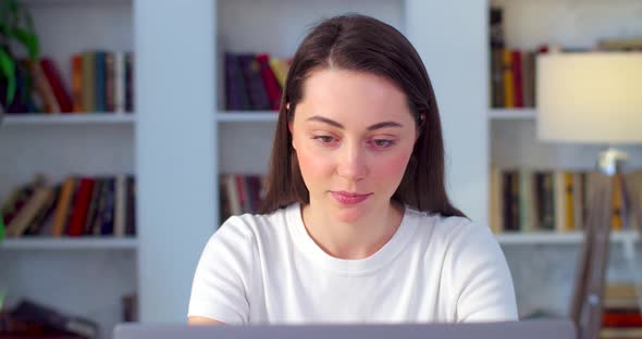 Young Female Student Finishing Work on Computer Laptop Smiling Happily Indoors Apartment Background