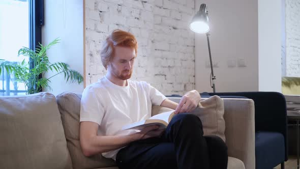 Creative Casual Man Reading Book Sitting on Sofa