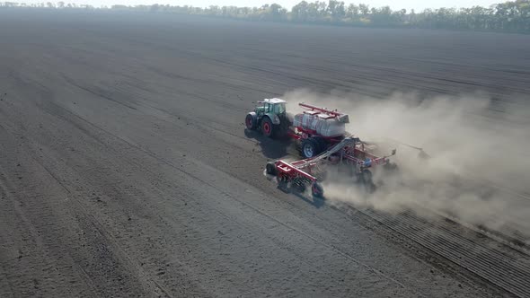 Side View of Tractor Sowing Seeds with Seeder Driller in Field