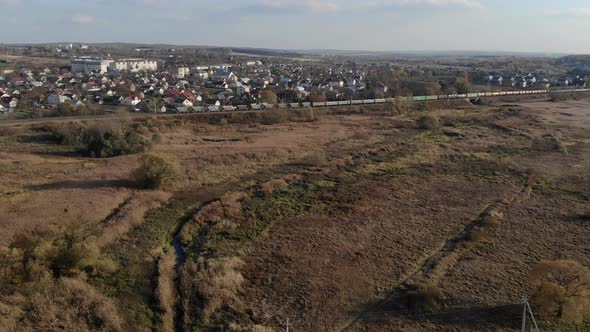 Aerial View of Movement of the Train with Freight Cars. The Train Rides on the Background