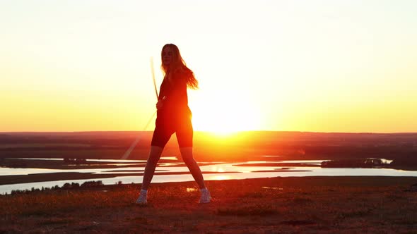 Swords Training Young Woman with Long Hair Training with Two Swords on the Background of the Bright