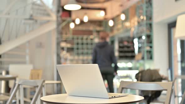 Laptop Kept Open on Cafe Table