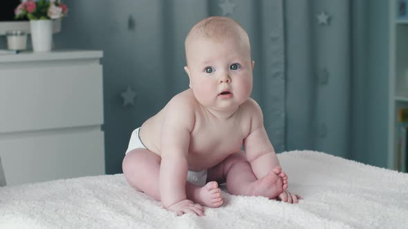 Baby Sitting on a Bed