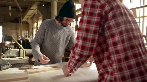 Two Male Workers Dimensioning Wooden Workpieces Using Special Tools in Joinery