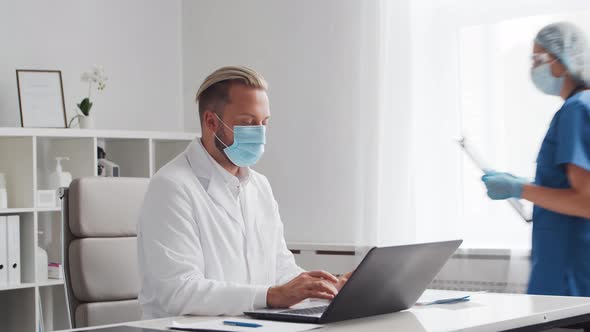 Professional medical doctor is working in hospital office using computer.