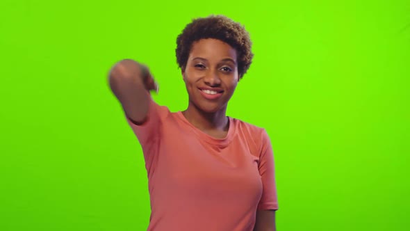 African American Girl Shows Thumb-up Posing at Green Wall