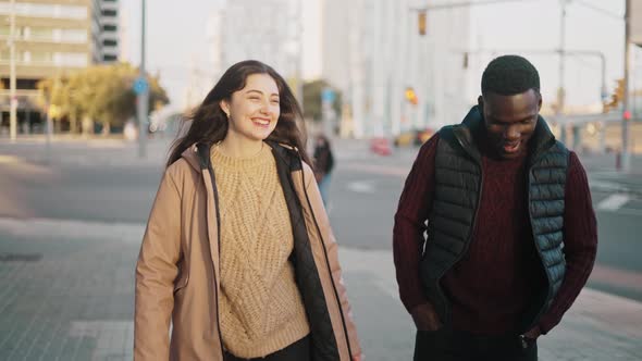 Smiling Multiracial Friends Walking Together in City