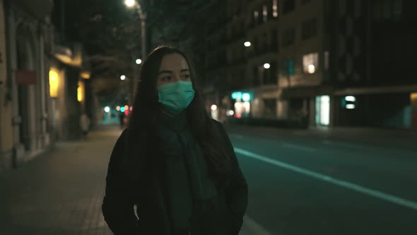 Female Model Wearing Mask Against Virus Walking Alone in the Night City