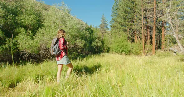 Hiking Woman Slow Motion. Traveler Girl in Skirt, Red Shirt with Backpack 