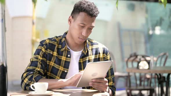 Young African Man Using Tablet, Outdoor Cafe