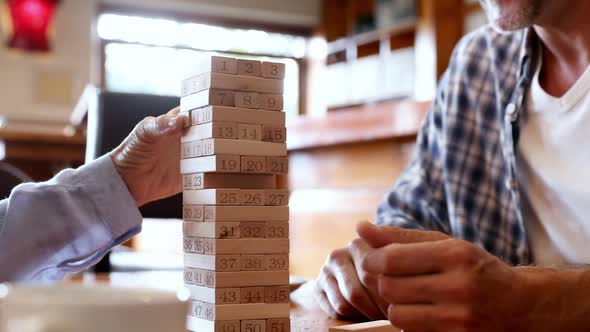 Mid section of friends playing jenga 4k