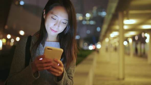 Woman text message on cellphone at evening in Hong Kong 