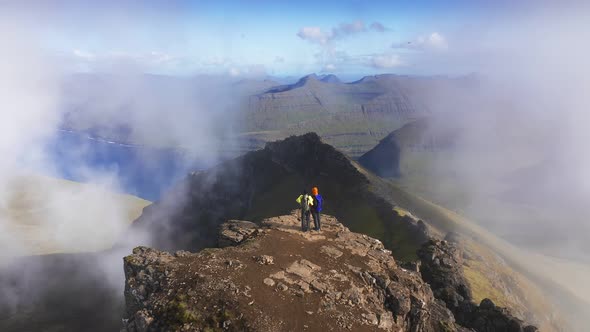 Aerial View of Two People on the Top of Mountain Looking the Beautiful Landscape Sea Cliff Mountain