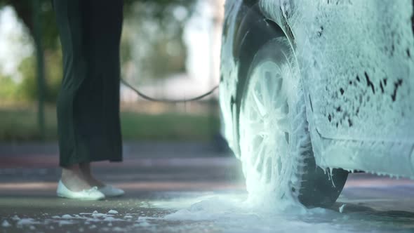 Closeup Car Wheel Tire with Water Washing Off Shampoo in Slow Motion