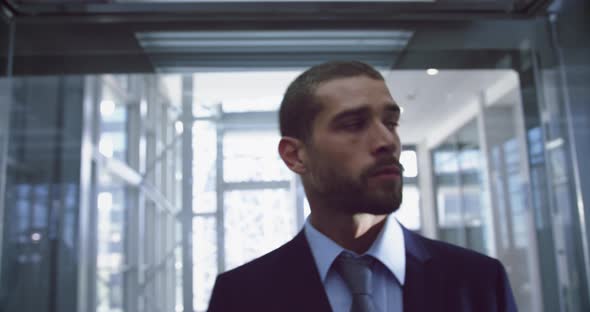 Businessman getting out of elevator at modern office 4k