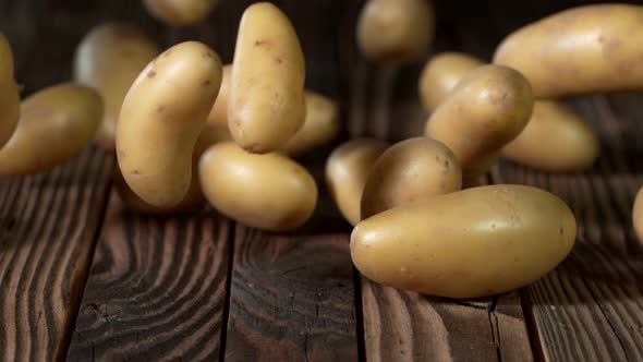 Super Slow Motion Shot of Potatoes Rolling on Old Wooden Table at 1000Fps