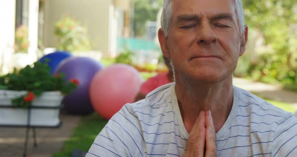 Senior friends performing yoga in garden 4k