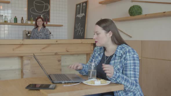 Busy Female It Programmer Working on Laptop in Cafe