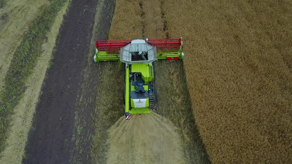 Combine Harvester Working On A Field. Aerial view of combine harvester on farm field