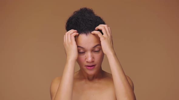 Beauty Portrait of Young African American Woman Looking in Mirror Touching Face and Correcting Hair