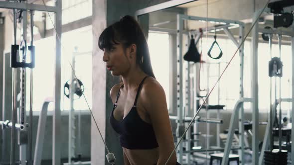 Fit Young Woman Doing Cable Cross Over Chest Exercise at the Gym