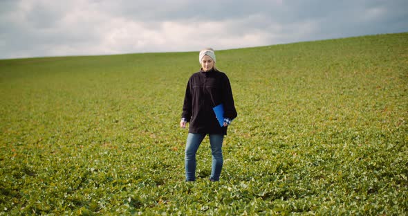 Female Farmer Examining Oilseed Rape Field