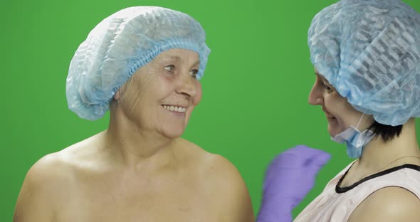 Smiling Elderly Female in Protective Hat. Plastic Surgeon Checking Woman Face