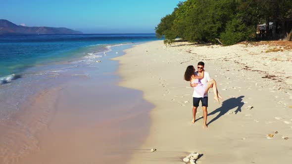 Guy and girl in love on beautiful shore beach wildlife by blue sea with white sand background of Gil