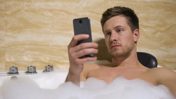 Man Resting in Bathtub and Chatting With Girlfriend, Upset by Canceled Date