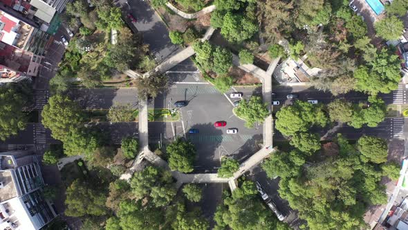 Aerial Top Down View of Cars Driving Below a Pedestrian Bridge