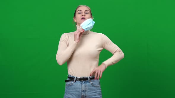 Brunette Caucasian Woman Taking Off Covid19 Face Mask Sighing and Smiling Looking at Camera