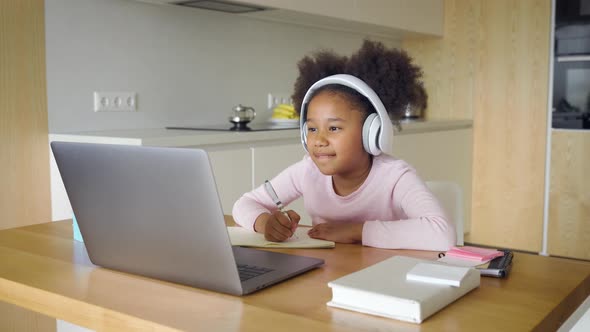 Little African American Girl Studying From Home Answering During Online Lesson