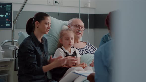 Close Up of African American Nurse Talking to Patient and His Family