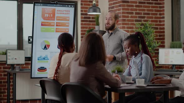 Business Man Discussing Company Growth with Analysis on Monitor