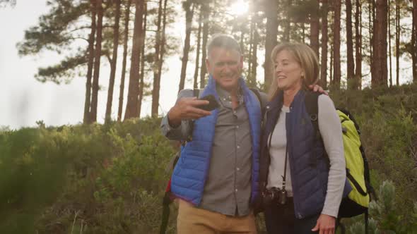 Active senior couple taking selfie in forest