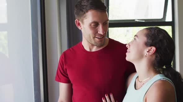 Happy caucasian couple talking and looking out the window