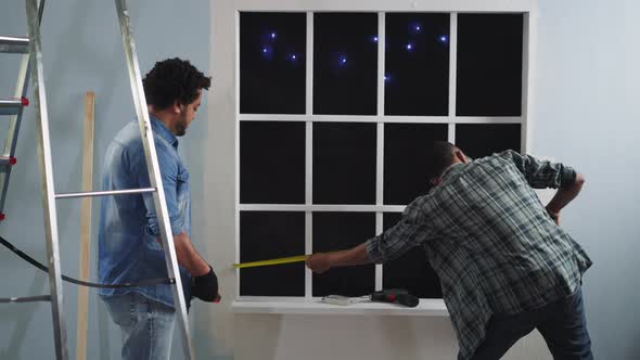 AfricanAmerican Man Measures Window Length with Colleague