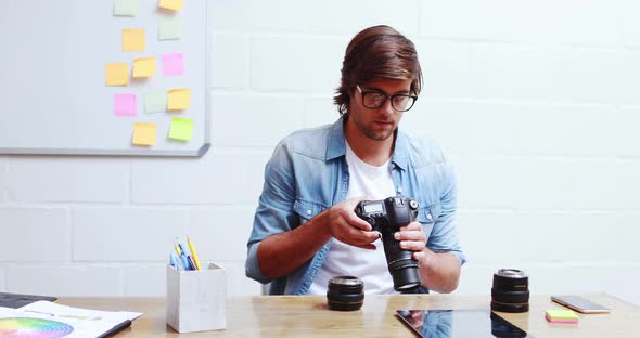 Man checking photos in camera and using digital tablet