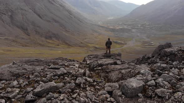 Aerial View of a Wide Valley and a Tourist Observing the Mountains From Cliff