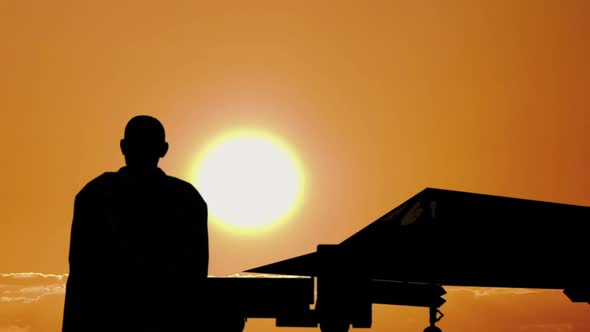 Silhouette of a Jet Pilot and Fighter at Sunset