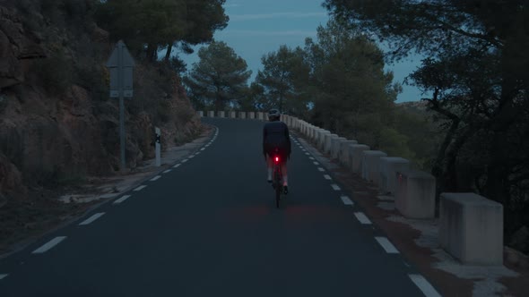 Young Professional Female Cyclist on Road Training