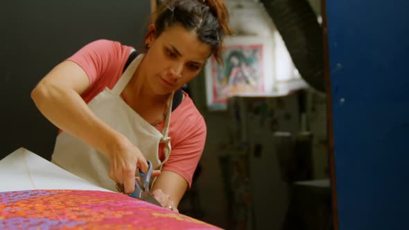 Woman cutting fabric for surfboard 