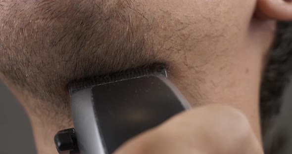 Man Shaving Stubble on His Neck and Chin with a Trimmer