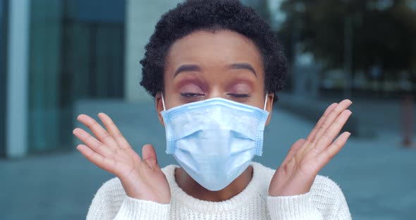 Close-up of Surprised Woman of African Ethnicity Wears Medical Mask on Female Face Actively