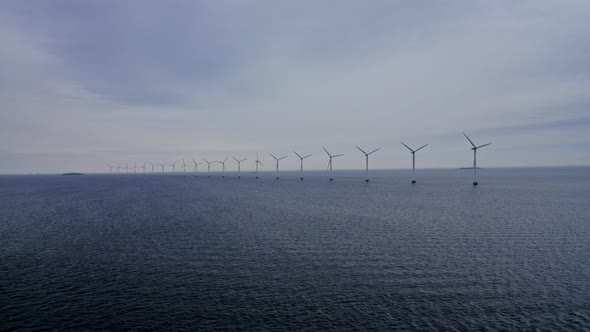 Calm Sea Waters and Windmills Rotating in Unison