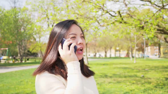 Asian black straight woman with happy face walking at the park and talking