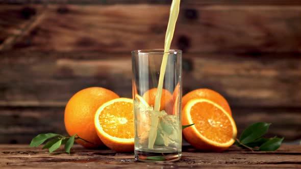 Super Slow Motion in the Glass Pours Orange Juice