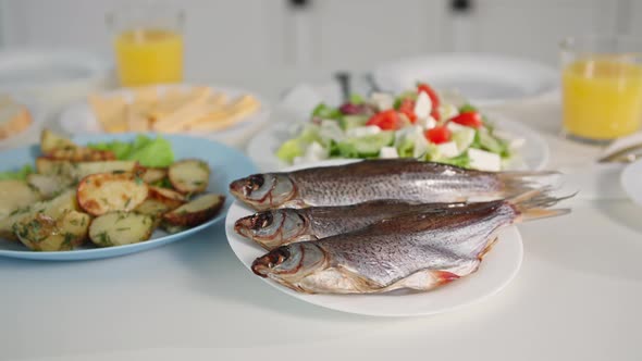 Proper Nutrition Healthy Fish Next to Vegetable Salad and Potatoes on the Table for a Family Snack