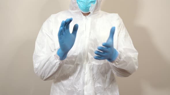 doctor in ppe suit pointing clapping and giving thumbs up in front of the camera