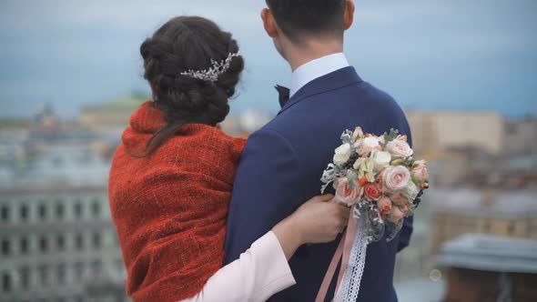 Couple Standing on the Roof. Happy Bride and Groom.